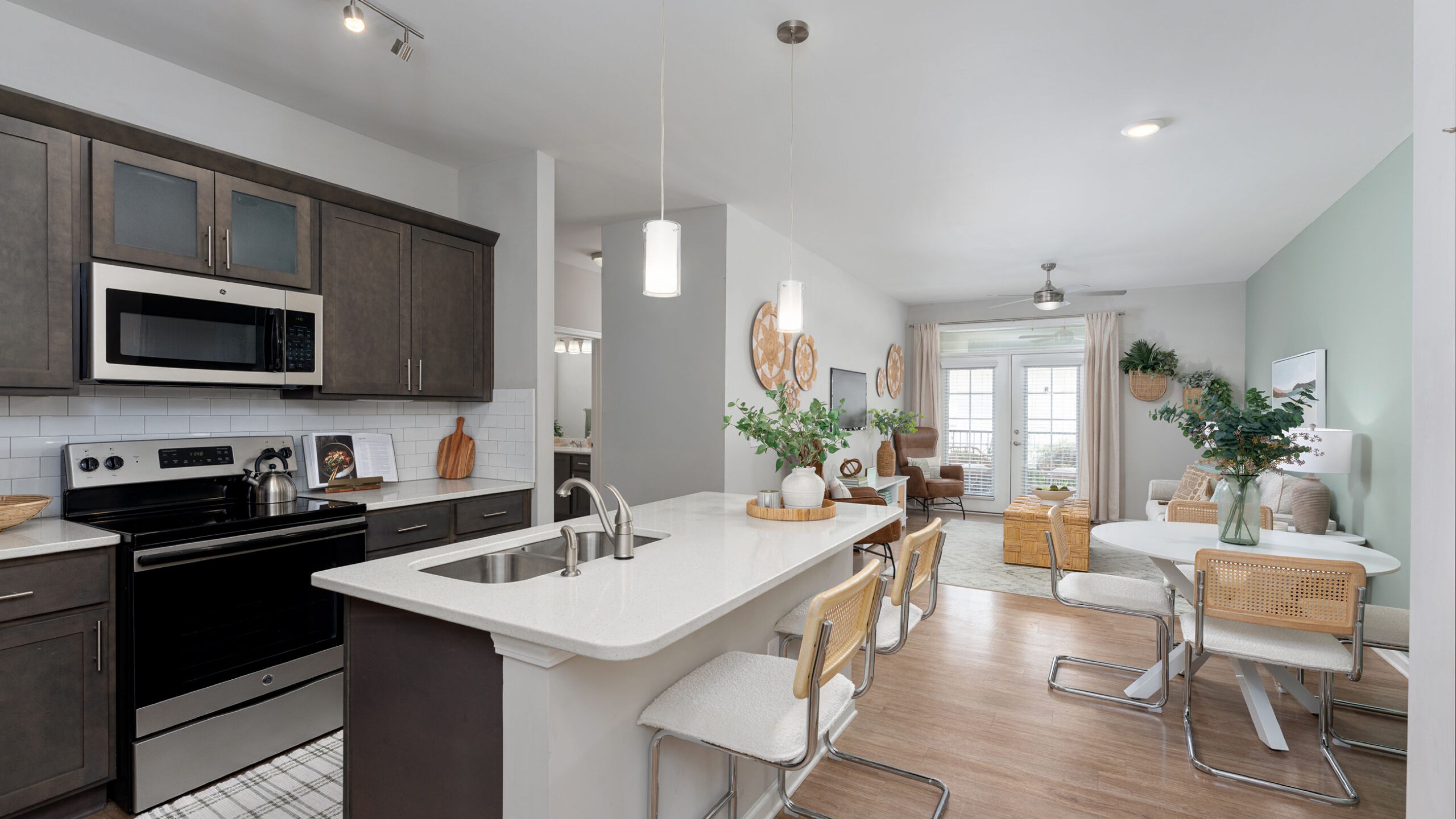 Hawthorne at Leland apartment interior dining area and kitchen with a dining table and chairs, kitchen island, and floor-to-ceiling cabinets