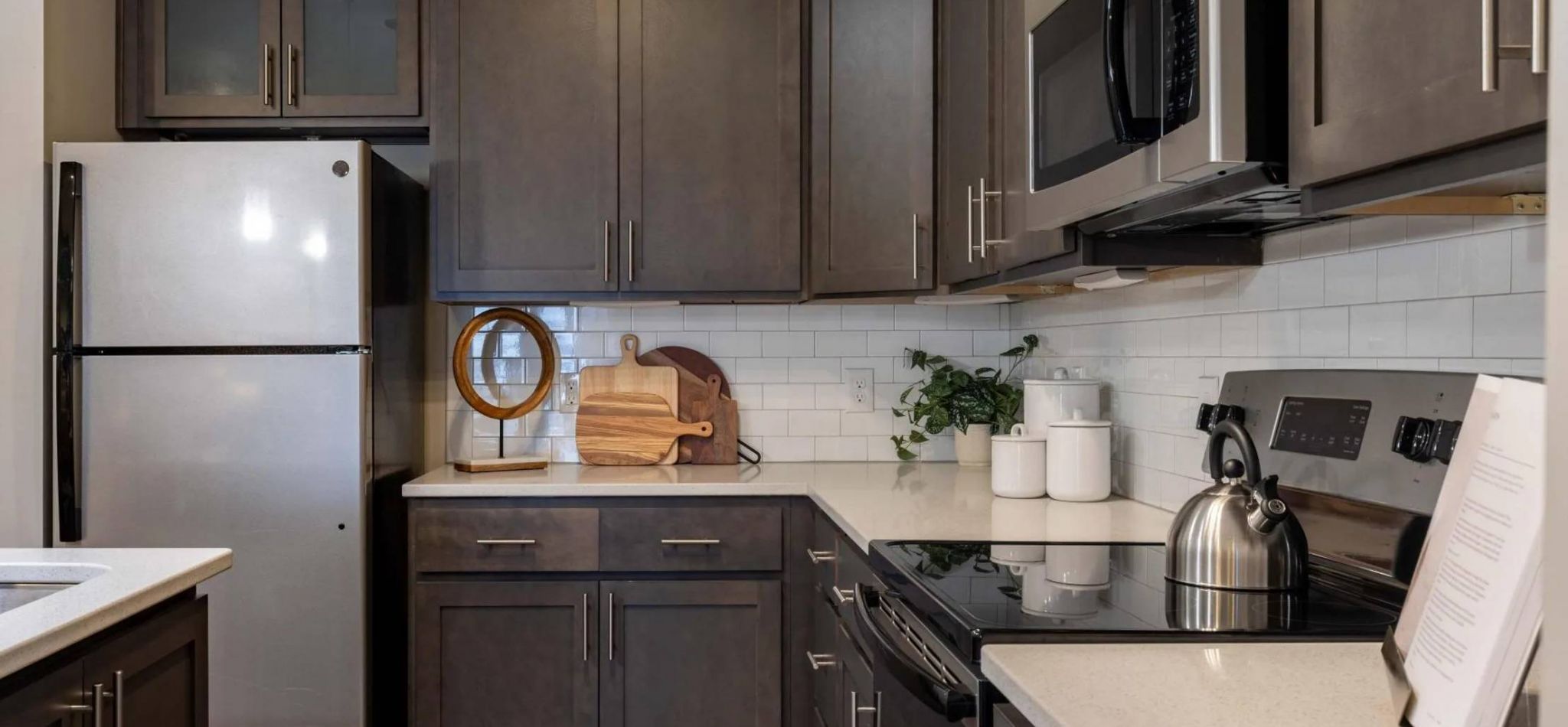 Hawthorne at Leland Hawthorne at Leland apartment kitchen interior with kitchen island, stainless steel appliances, and custom cabinetry