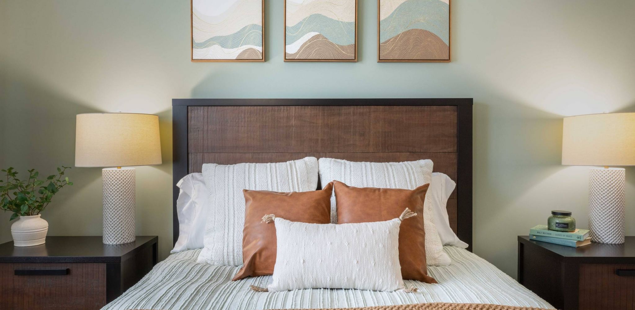Hawthorne at Lelandclose-up of queen-sized bed in apartment bedroom with an two night stands, and an earth-tone color palette.